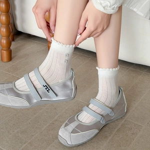 Détail de baskets Mary Jane gris clair à double boucle avec des chaussettes en dentelle