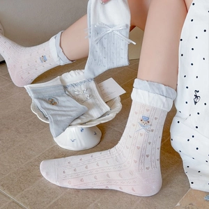 Detail of light blue mesh socks featuring handmade bows and cute bear embroidery accents