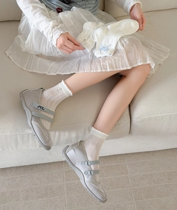 Détail de chaussettes blanches en dentelle portées avec des chaussures Mary Jane grises