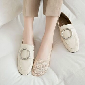 Detail of off-white loafers with silver metal buckle and lace invisible socks