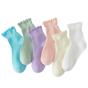 Close-up of 6 pairs of ruffled ankle socks in pastel colors with ribbed texture