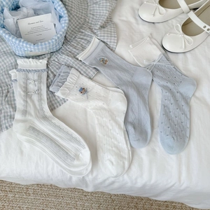 Close-up of bear embroidery and handmade bow on light blue mesh breathable crew socks