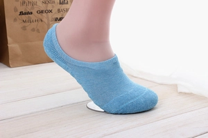Detailed knit texture of light blue low-cut invisible socks on a foot model