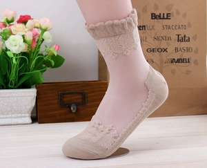 Close-up of beige lace ankle socks with ruffled cuffs and sheer transparent fabric