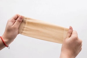 Detail der ultra-elastischen Dehnung und des seidigen Stoffes beige transparenter Socken
