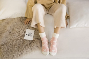 Detail of soft coral fleece winter socks in pink with heart patterns and cuffed edges