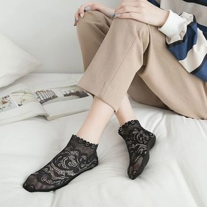 Detail of black floral lace ankle socks with hollow patterns and wavy scalloped edges