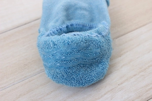Close-up of blue cotton boat sock heel showing three wave-shaped silicone anti-slip strips