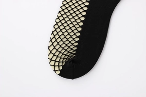 Detail of black fishnet socks featuring reinforced toes and fine mesh texture on a foot form