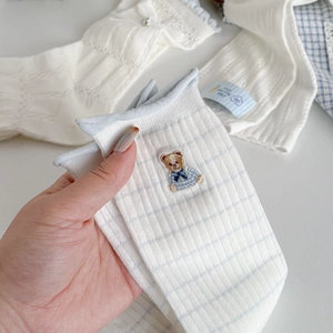 Close-up of white ribbed cotton socks featuring a sweet blue bow bear embroidery detail
