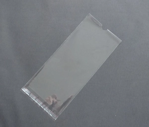 Close-up of a clear self-adhesive OPP packaging bag with a red peel-off sealing strip