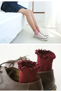 Close-up of ribbed knit cotton socks featuring delicate ruffled lace cuffs and soft texture