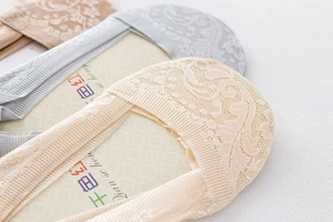 Detailed close-up of lace invisible socks with delicate floral patterns and elastic edges