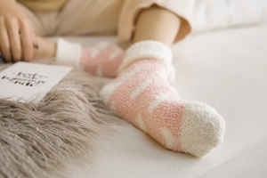Close-up of pink striped coral fleece socks with white faux shearling cuffs for winter