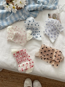 Detail of five pairs of sheer glass silk socks featuring colorful flocked heart patterns