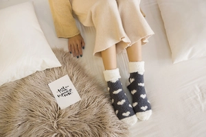 Detailed texture of thick dark grey coral fleece socks with white heart pattern