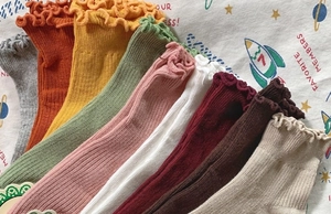 Detailed view of colorful ribbed cotton socks with ruffled edges in nine various colors