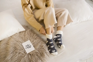Close-up of thick coral fleece winter socks with heart patterns and plush fleece cuffs