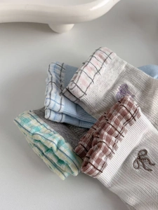 Detailed view of mesh socks featuring bow embroidery and diverse knit patterns