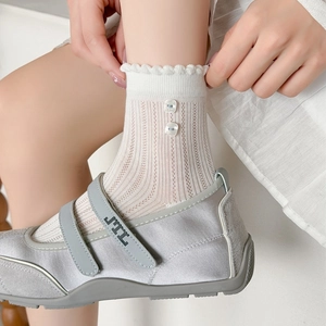 Chaussettes résille blanches à volants et boutons décoratifs portées avec Mary Janes