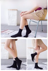 Three-way view of comfortable black rolled-top socks in combed cotton on model