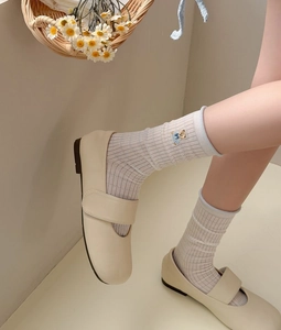 Detail of white cotton crew socks with cute embroidered bear and Mary Jane shoes