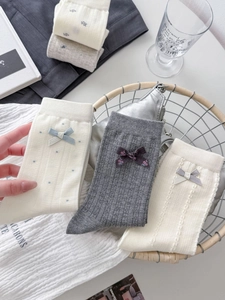 Detail of cotton socks featuring bow ribbon, delicate rib knit and polka dot patterns