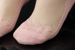 Close-up of pink lace invisible socks showing delicate floral patterns and cotton texture