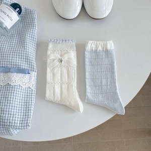Detailed view of light blue mesh socks with hollow knit and white lace bow decoration