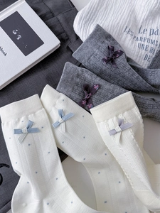 Detail of cotton crew socks with bows, polka dots, and rib textures in a flat lay view