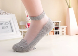 Detail of gray invisible boat socks with lace edges and a small crown pattern design