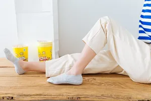 Lace boat socks for women in light grey, featuring delicate floral texture on model