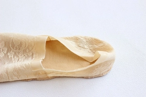 Detailed macro view of beige lace invisible boat socks with breathable mesh texture