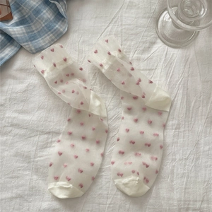 Detailed view of white semi-transparent socks featuring pink heart patterns and reinforced toe
