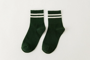 Detalle de calcetines de algodón verde oscuro con rayas blancas dobles y tejido de canalé