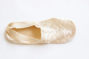 Detailed close-up of light beige crochet lace invisible socks with floral patterns