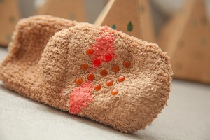 Close-up of warm coral fleece children's socks with red anti-slip silicone dots on soles