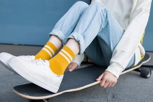 Calcetines retro amarillo mostaza con rayas blancas combinados con zapatillas y monopatín