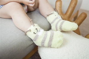 Detail of coral fleece baby socks with cartoon embroidery and 3D decorative antennae