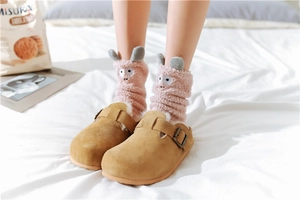 Detail of pink coral fleece socks with cute 3D cartoon ears and brown suede mules