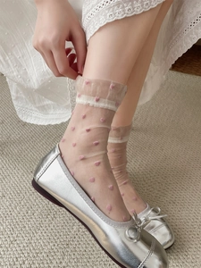 Detail of sheer glass silk socks with pink heart dots and ruffled cuffs for women