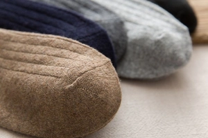 Macro shot of thick winter wool socks showing warm ribbed texture and fine toe stitching
