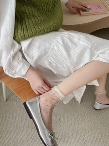Close-up of sheer Japanese glass socks with pink dots paired with silver bow shoes