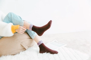 Nahaufnahme dicker Wintersocken in Weinrot mit weichen lila Fleece-Bündchen