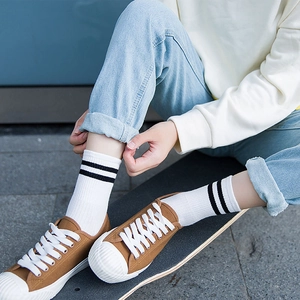 Calcetines de algodón blanco con rayas negras en un monopatín para estilo callejero