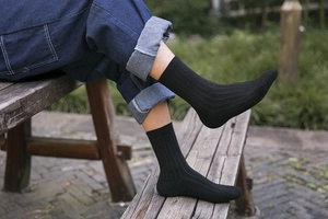 Detail of black ribbed wool socks for men with high elasticity in outdoor setting