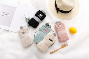 Detailed view of soft coral fleece socks with cute cartoon monster faces and 3D ears