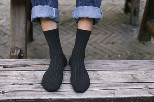 Close-up of men's winter thermal wool socks featuring black vertical rib knit texture