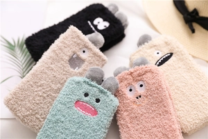 Close-up of five colorful coral fleece socks with cute cartoon monster embroidery details