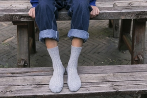 Detailed close-up of light gray ribbed wool socks for men during outdoor wear